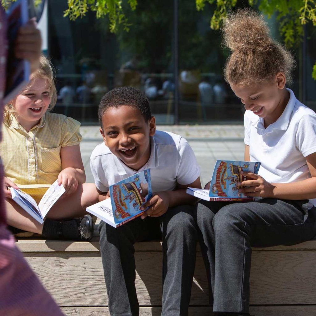 Children with books laughing
